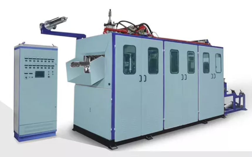 A thermoforming machine in action, heating a plastic sheet and molding it into a specific shape using a detailed mold.